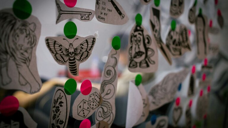 Tattoo stencils hanging on a wall