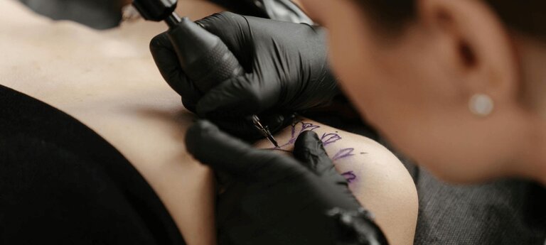 Woman getting a tattoo on her shoulder
