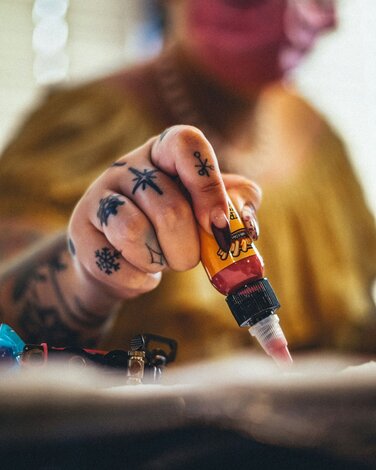 Tattoo Artist filling ink cups