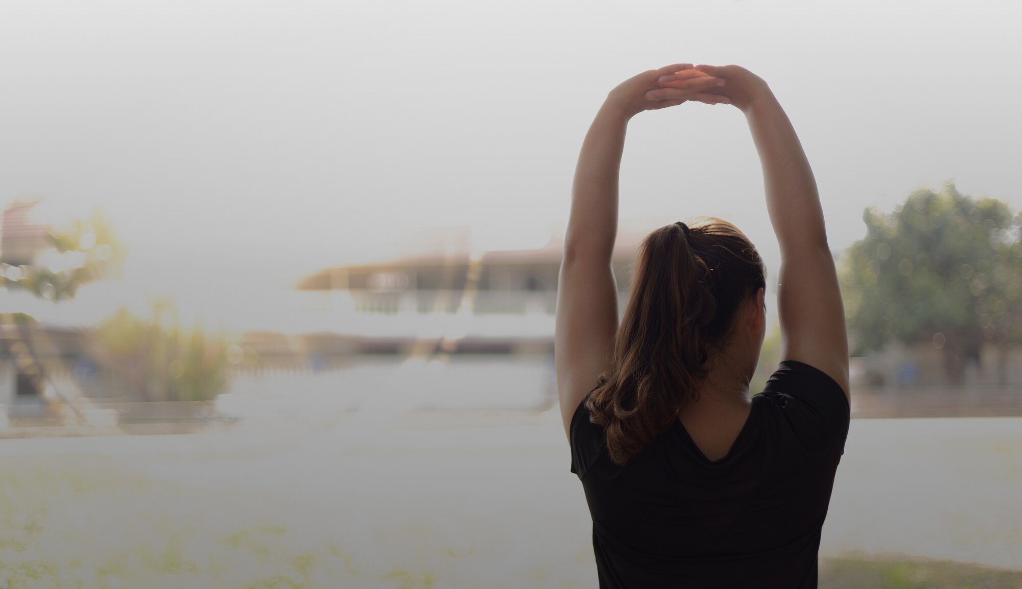 Eine junge Frau, die sich nach der Schmerztherapie entspannt streckt