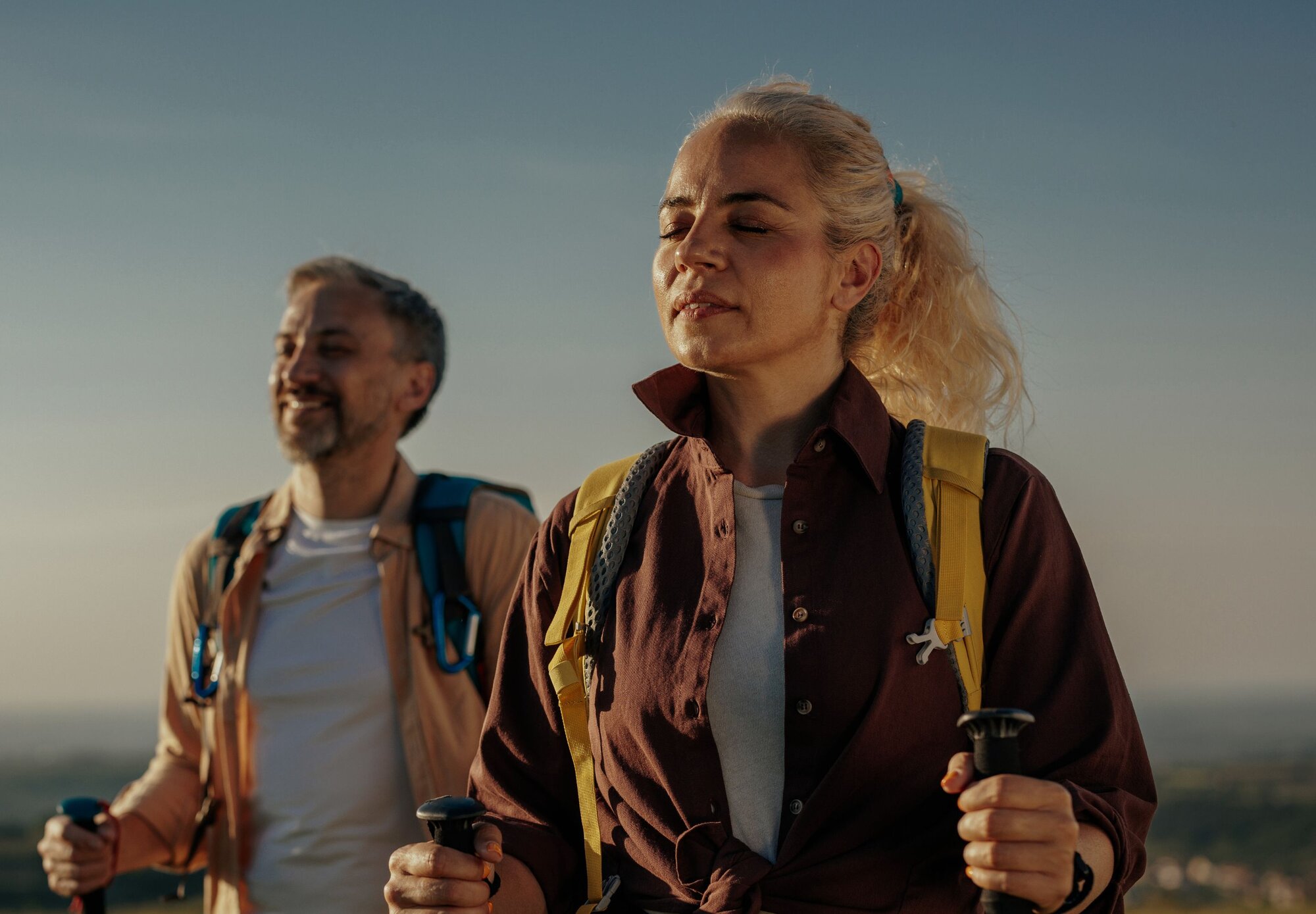 Frau und Mann atmen in der Natur beim Wandern