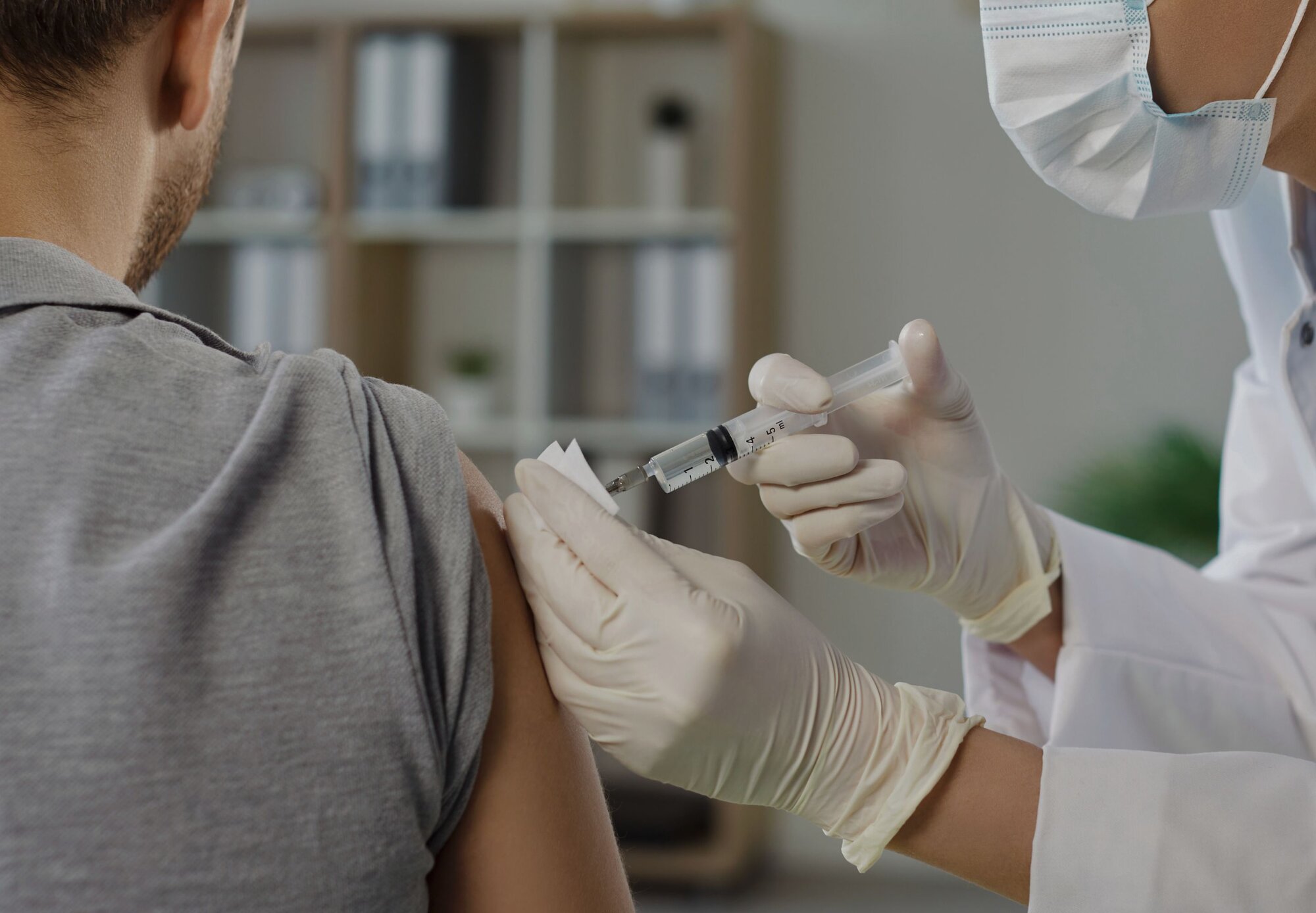 Eine Frau nach ihrer Corona Impfung mit Pflaster am Oberarm