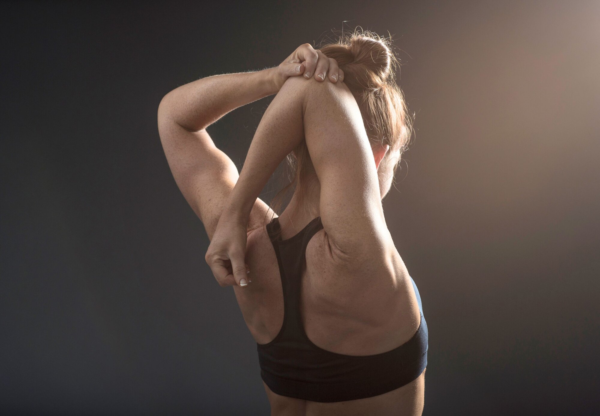 Eine junge Frau, die sich bei der Physiotherapie entspannt streckt