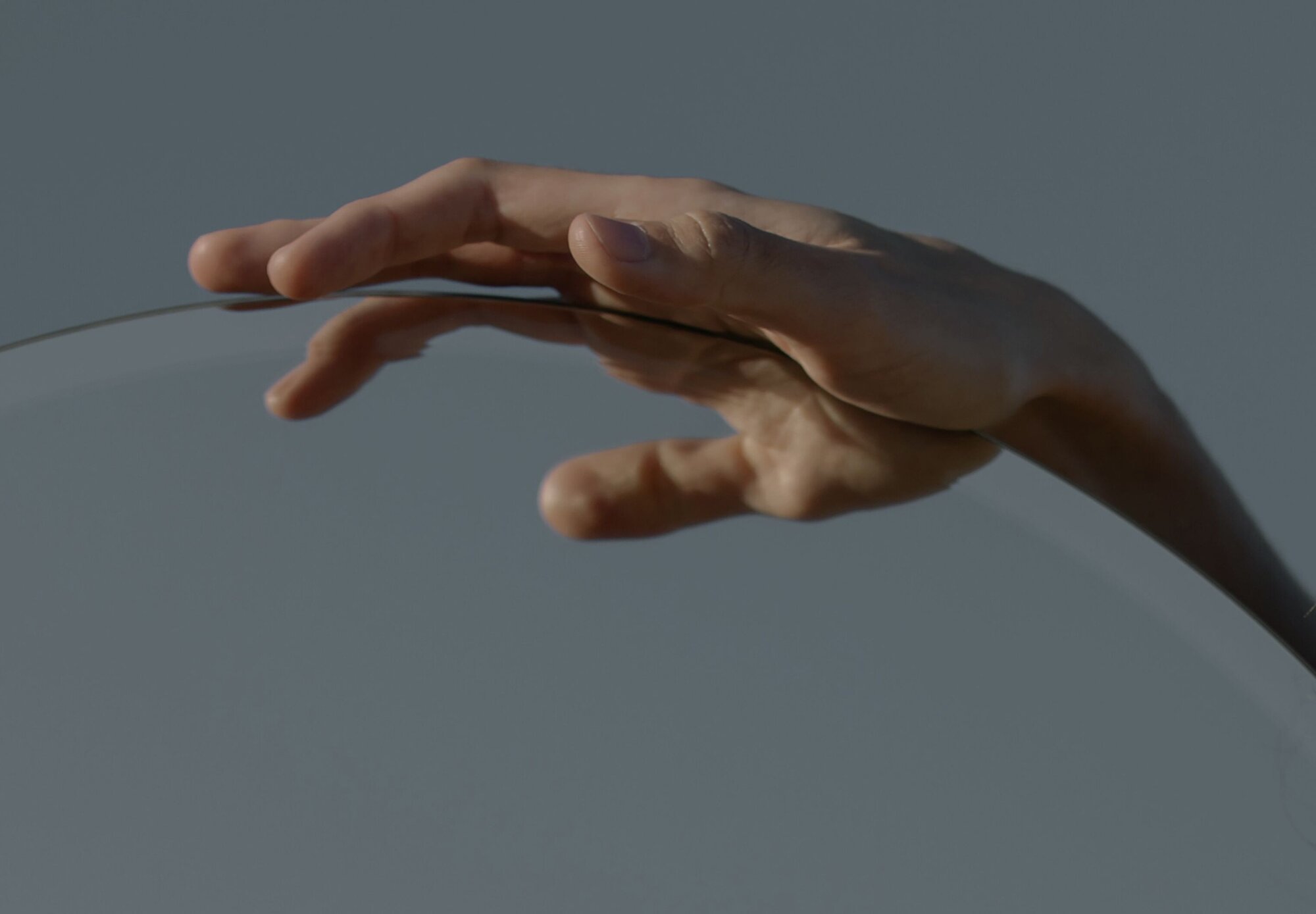 Nahaufnahme einer Hand die durch Gras streift