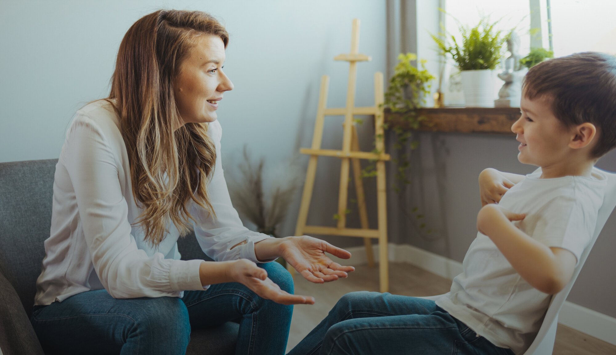 Eine Kinderpsychotherapeutin unterhält sich beim Kinderpsychologie Termin mit einem Kind.