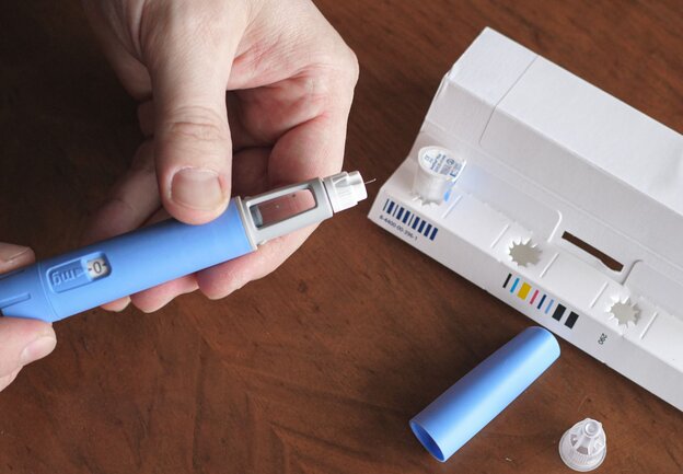 Mann hält Abnehmspritze in der Hand