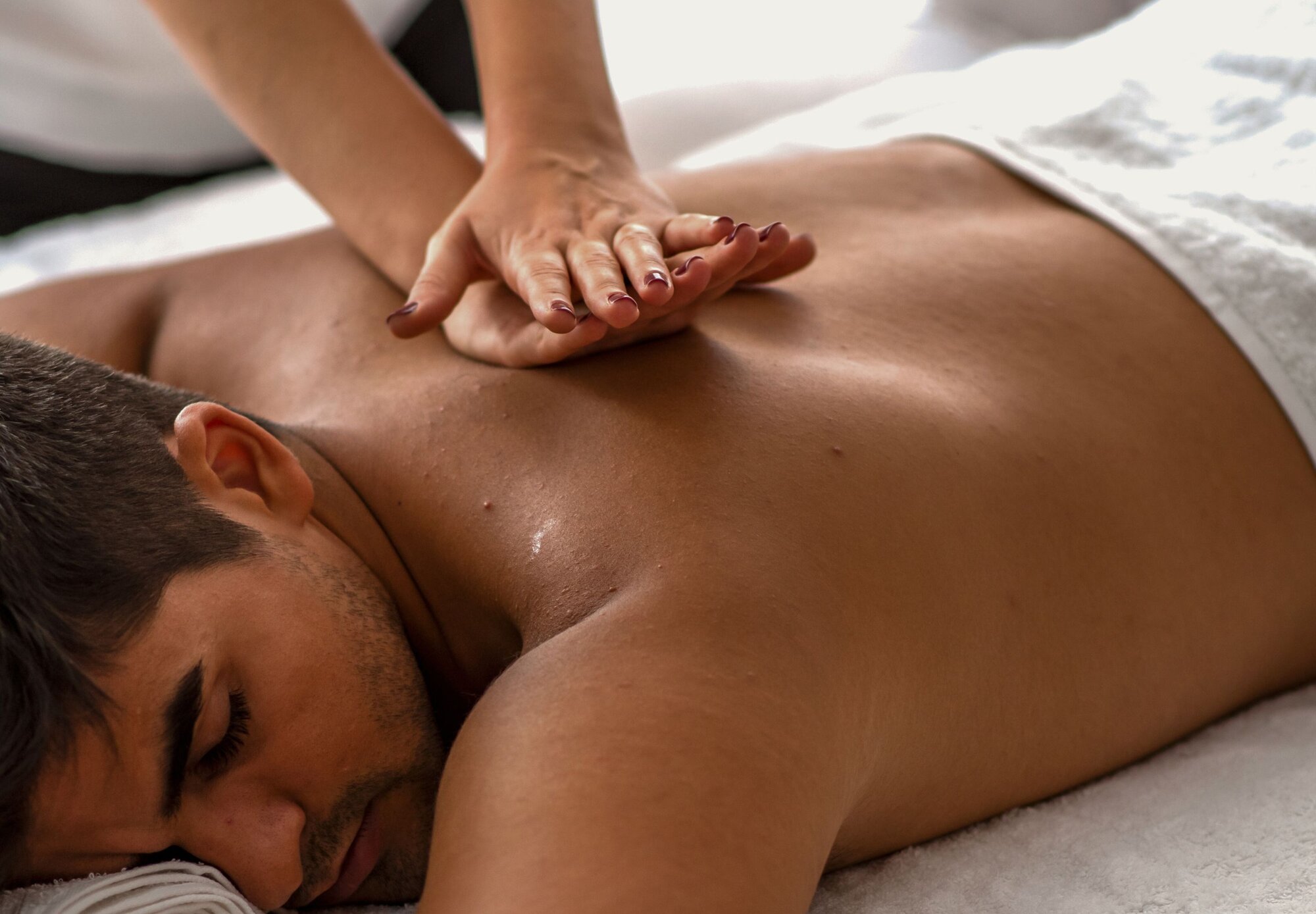 Heilmassage Leistung: Ein Mann wird von einer Frau massiert