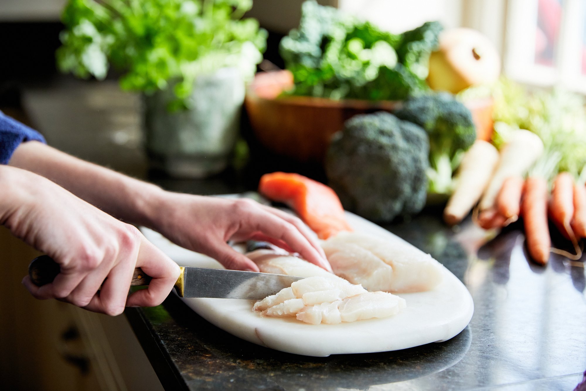 Different Dog chef cutting up raw fish, ready to be prepared for our dog food recipe 