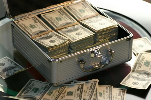 Briefcase filled with bundles of U.S. dollar bills, symbolizing financial aspects such as divorce costs, legal fees, or property settlements.