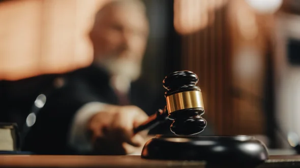A judge hitting a gavel pad with his gavel
