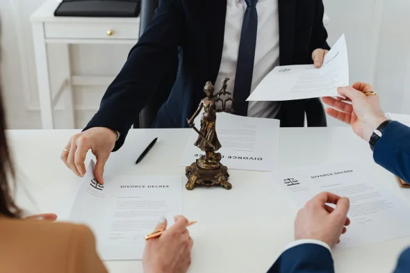 A group of people reviewing and exchanging divorce decree documents.