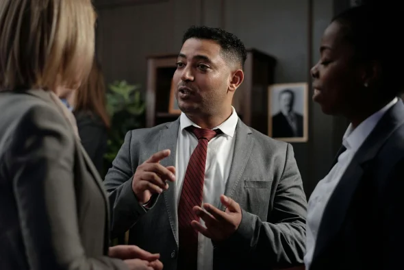 A lawyer in a suit having a discussion with colleagues in a law office.