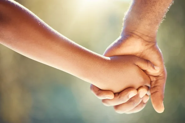 A parent and his child holding hands