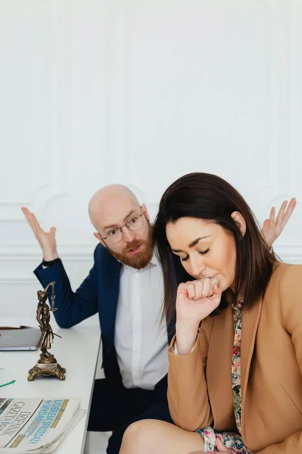 A husband and wife arguing in a white room.