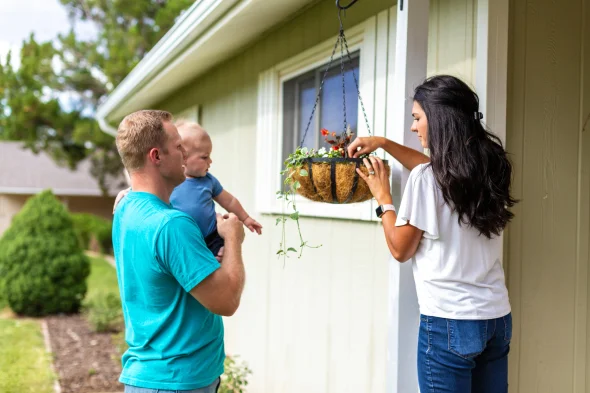 Two parents with their child decorating a home together