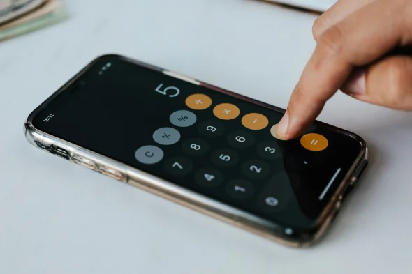 A person using the calculator app on his phone.