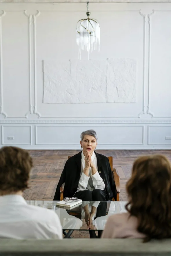 An attorney sitting across from a couple in a session.