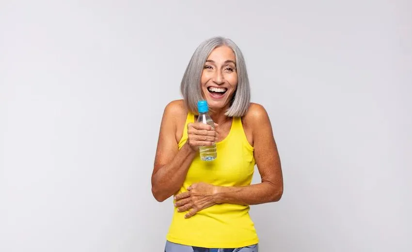 woman in yellow holding water bottle