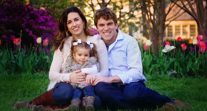 Photo of Ashleigh Gallagher, customer, and her family in front of flowers