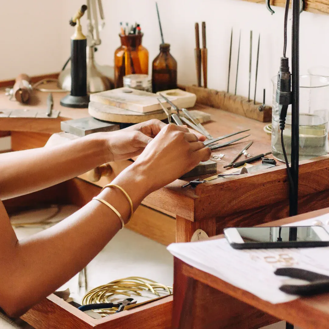 Someone making jewelry at a crafting station.