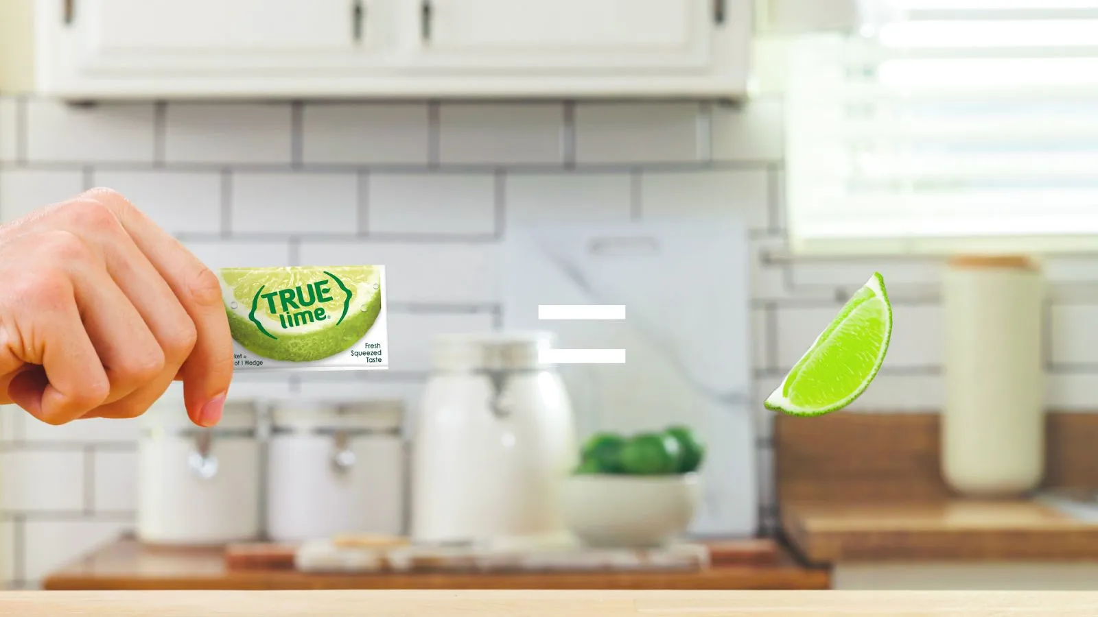 Hand holding a lime packet with an equal sign to a lime wedge.