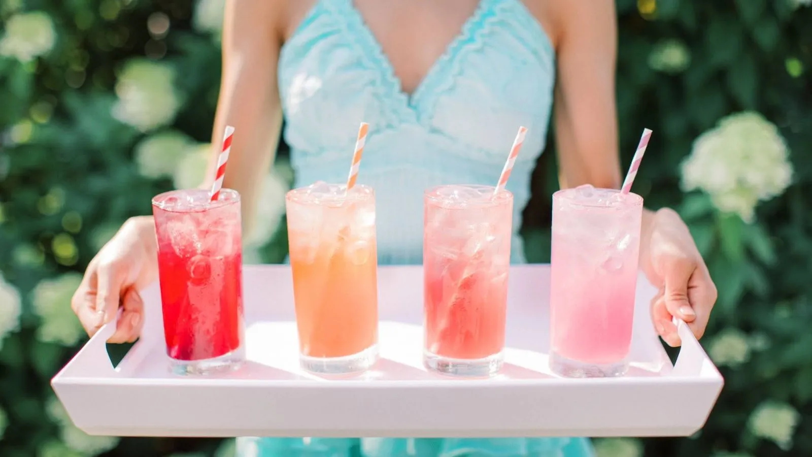 Woman Holding A Tray With Pink Lemonade And Other Varieties