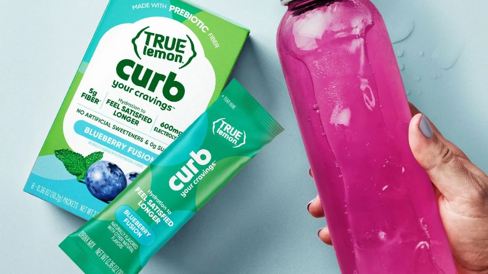 Hand Holding A Bottle Of Water Mixed With True Lemon Curb Blueberry Fusion