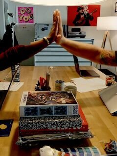 two team members high fiving over a table