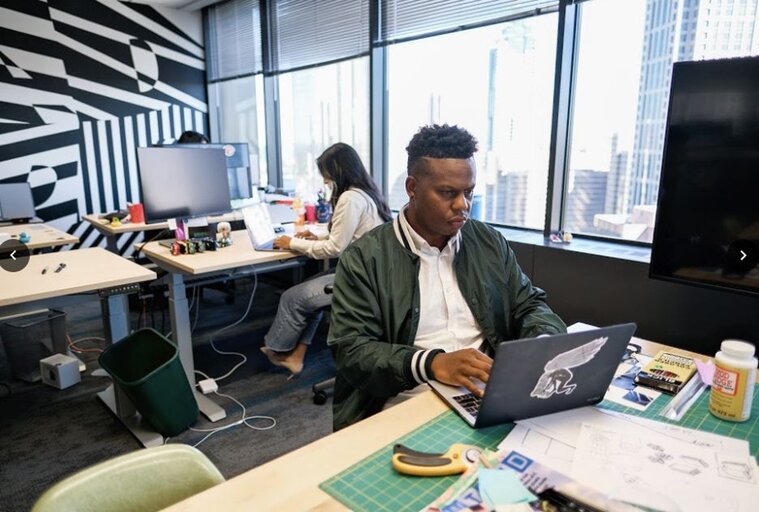 Three CallRail employees working on their laptops in the CallRail office