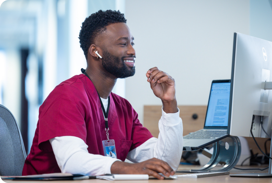 male in healthcare scrubs working on a computer