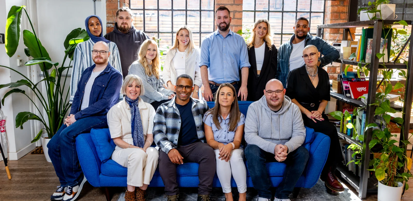 Develo eCommerce team - creative designers, technical developers and strategic experts gathered in modern office with exposed brick walls and plants