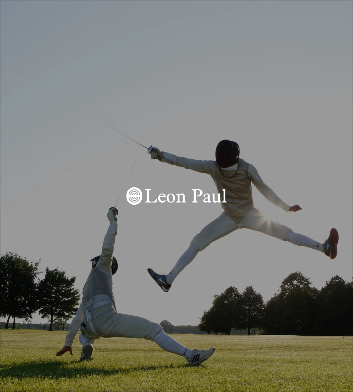 Leon Paul fencing athlete in action on grass field demonstrating professional fencing technique