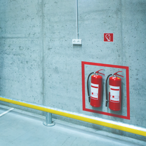 image of fire extinguishers positioned inside warning tape in warehouse