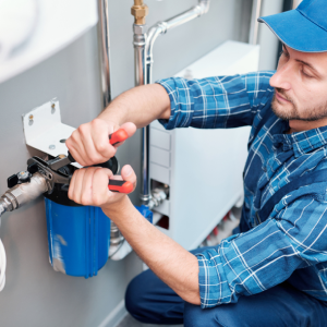 Image of a person using adjustable pliers on a component on a water filtration system.