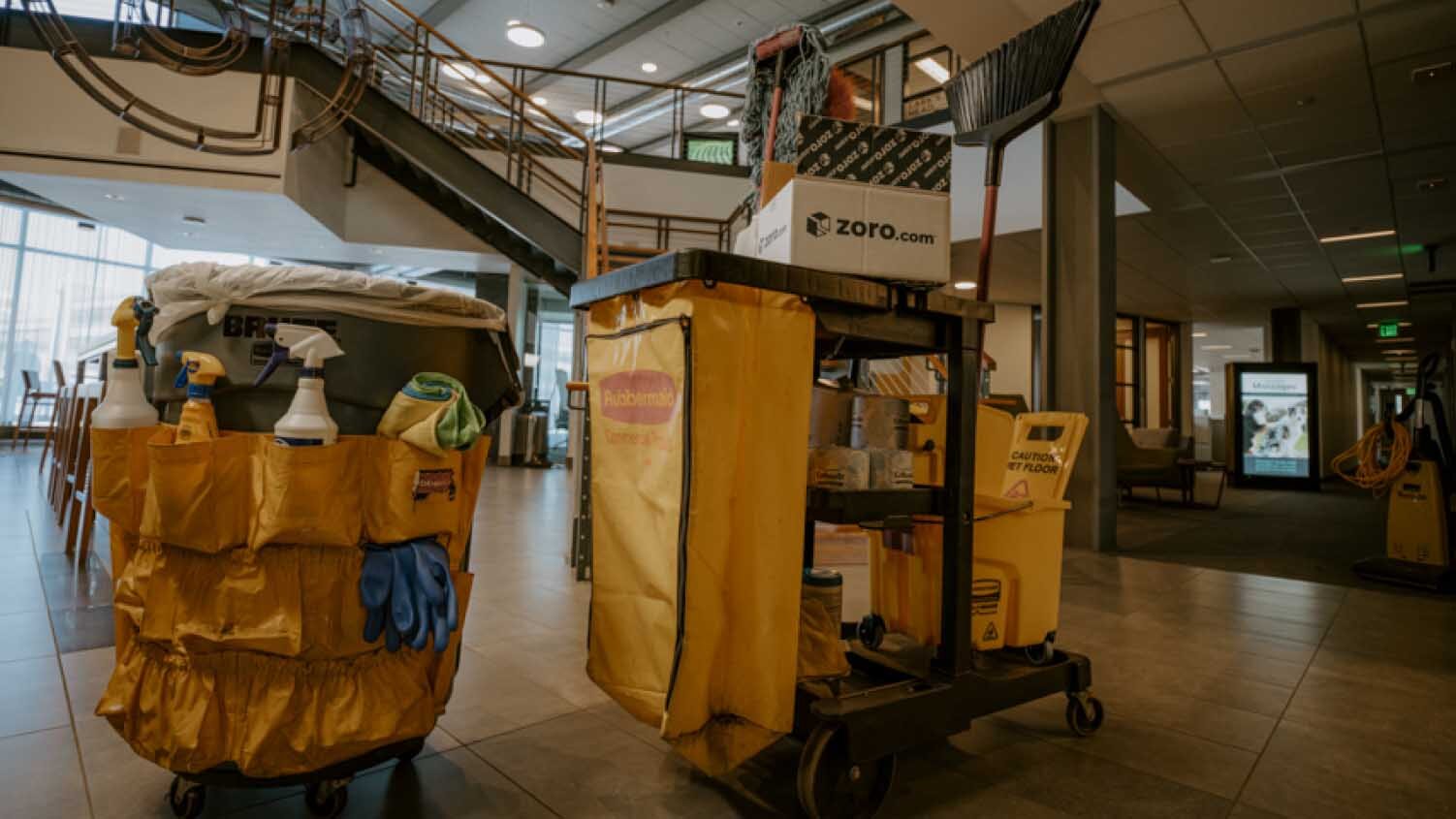 2 Rubbermaid janitorial carts with cleaning tools and chemicals