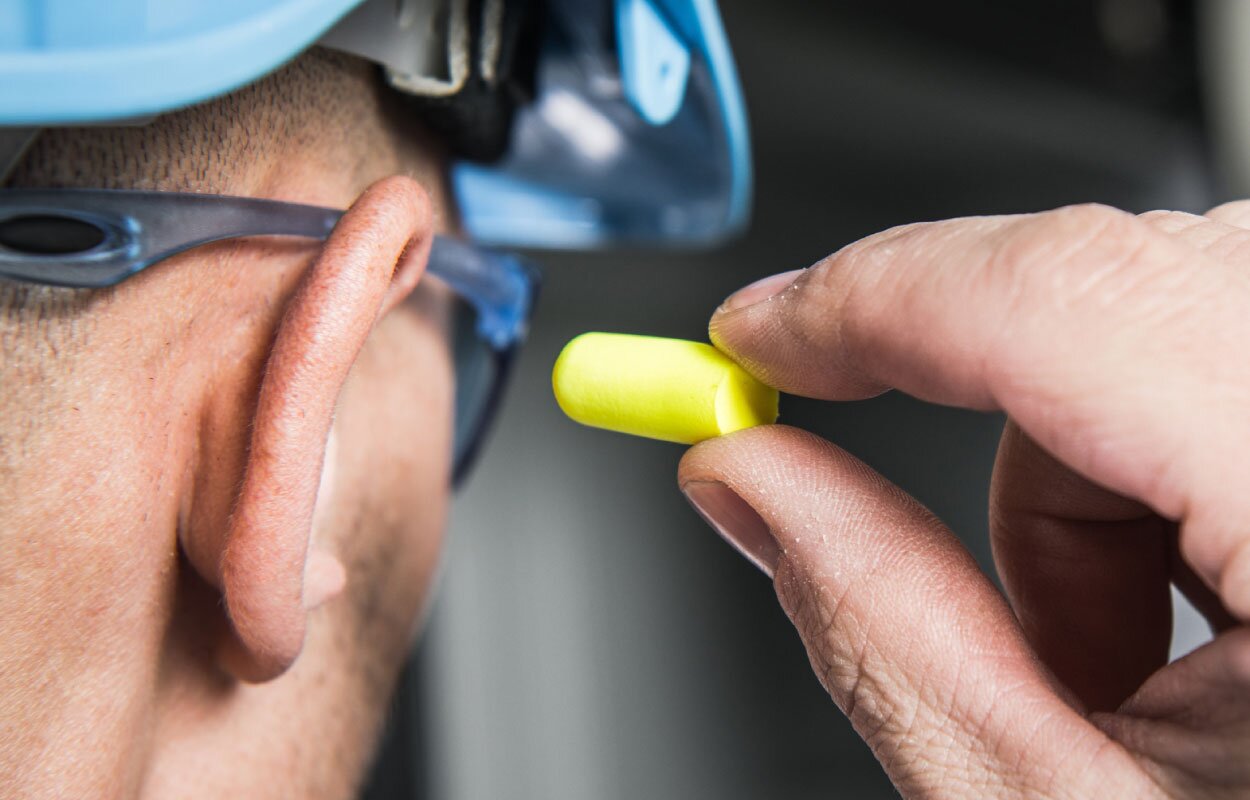 Construction worker putting ear buds