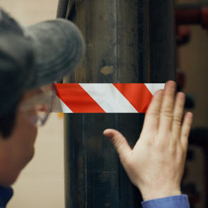 image of person placing warning tape on a pole
