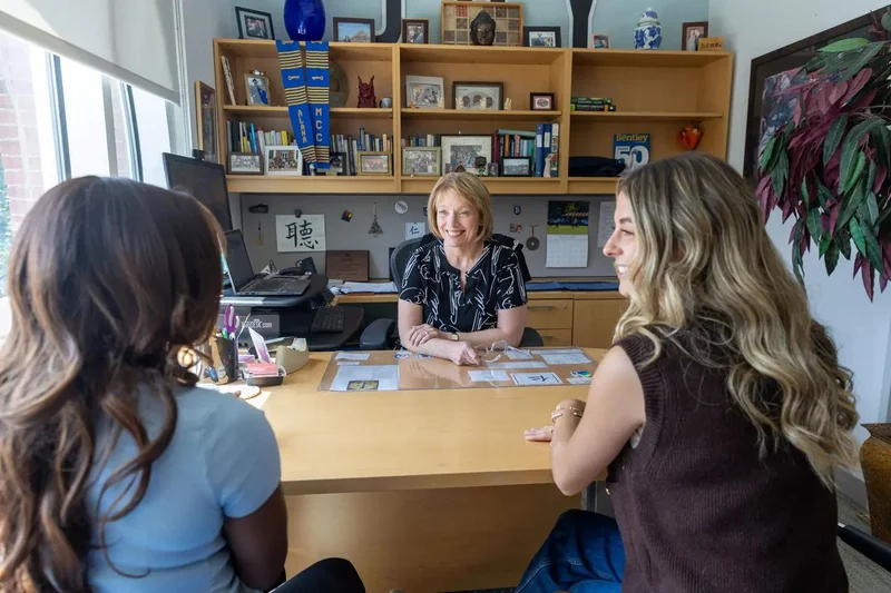 Advisor meeting with two colleagues at a desk to discuss renter support