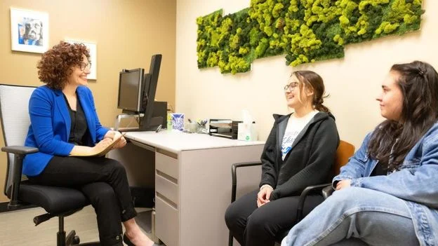 Advisor discussing renter education with two students during a consultation