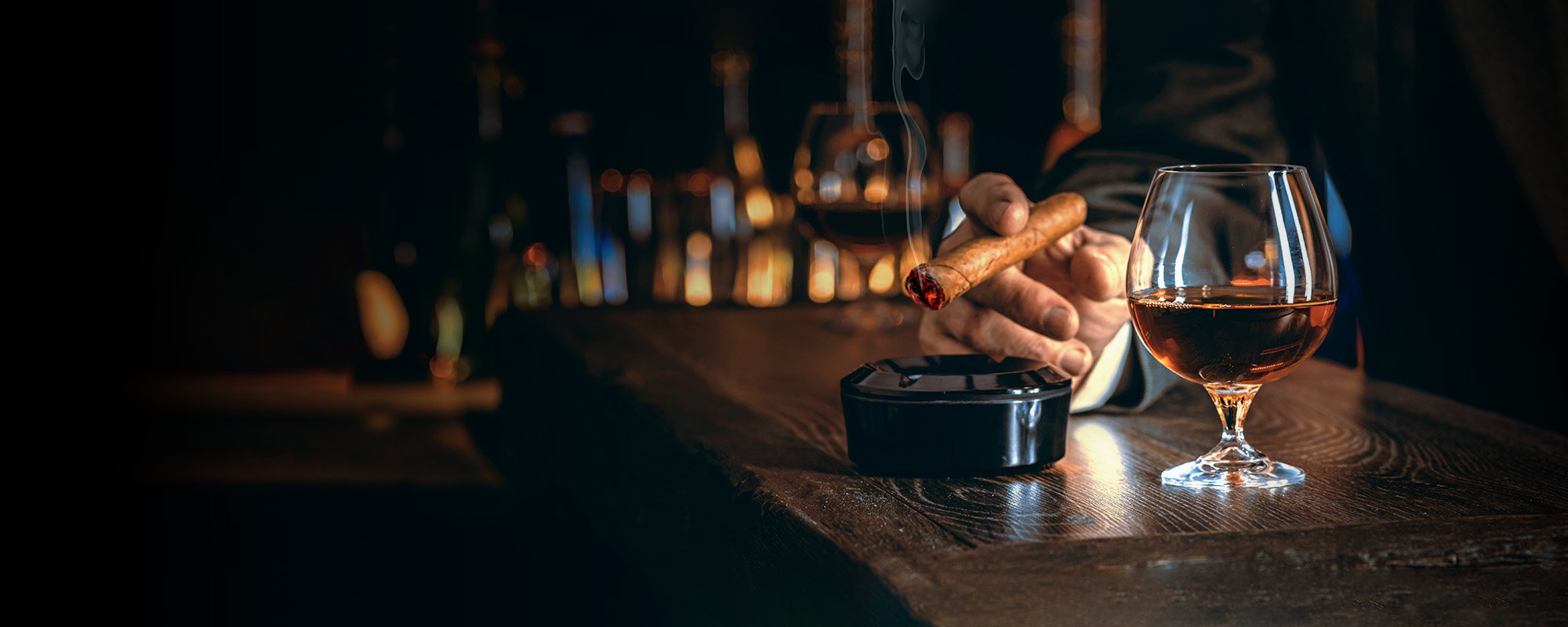an image of a cigar, ashtray and drink in a glass