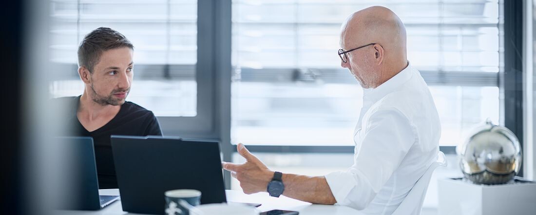 Zwei Personen auf der Arbeit sprechen miteinander