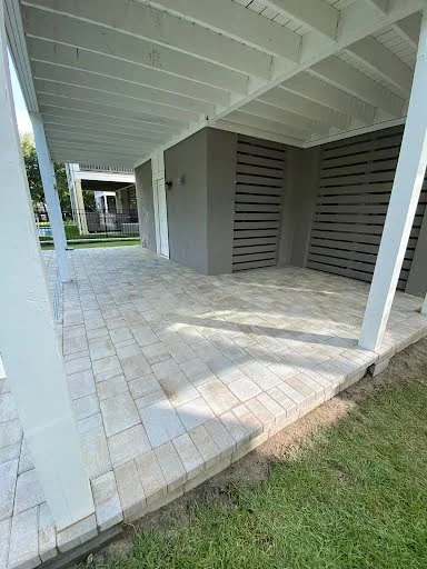 Finished paver patio beneath a covered coastal home