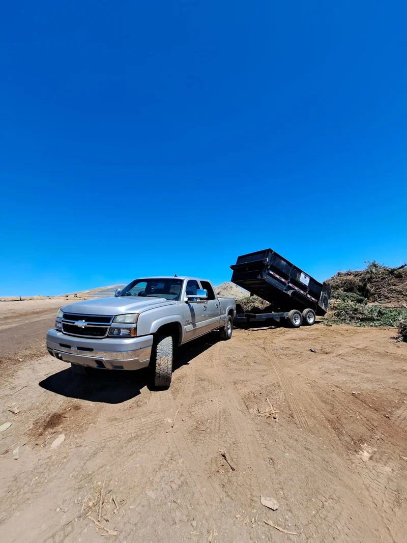 Pickup truck and dump trailer being used for debris removal