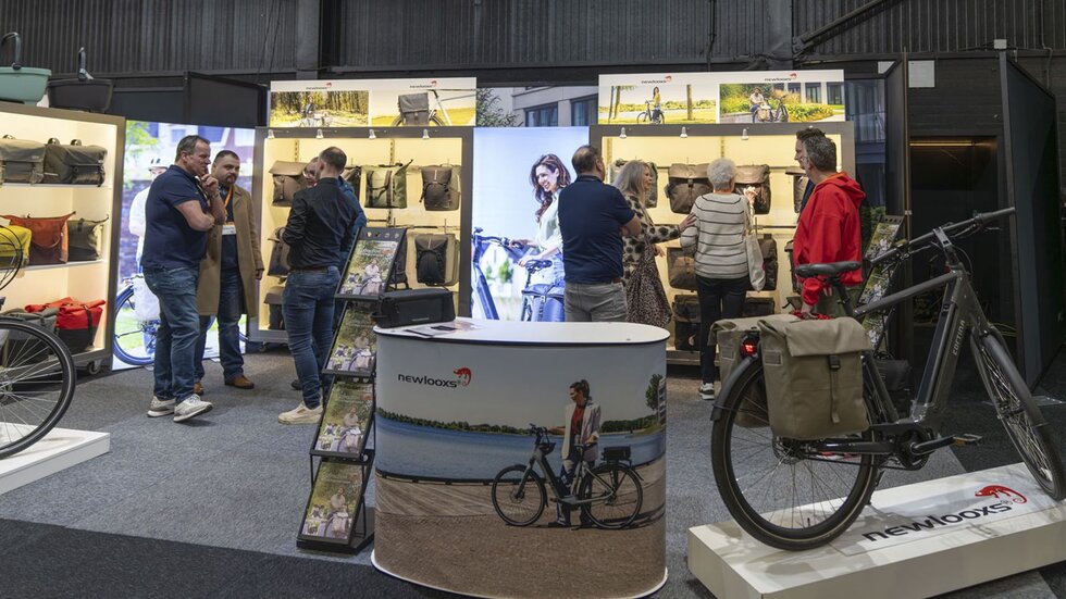 Links groene planten in beeld rechts vrouw loopt met fiets