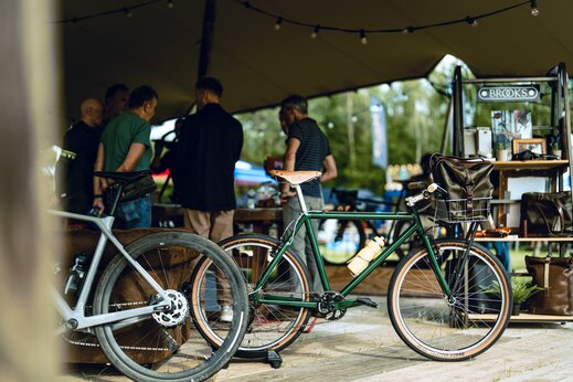 De brooks stand met brooks accessoires uitgelicht met daarachter bezoekers in gesprek
