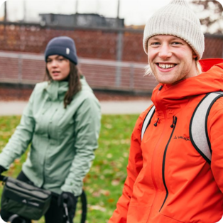 2 mensen op een fiets met accessoires van VAUDE in een natuurlijke omgeving. 