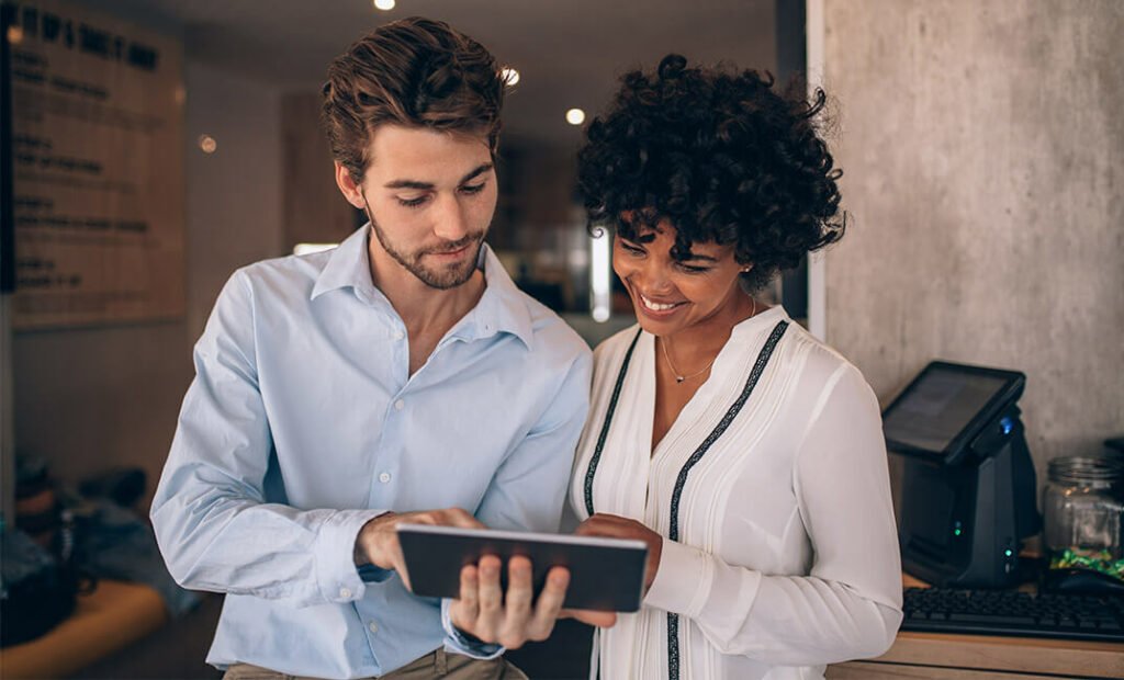 The woman and the man are looking at the tablet