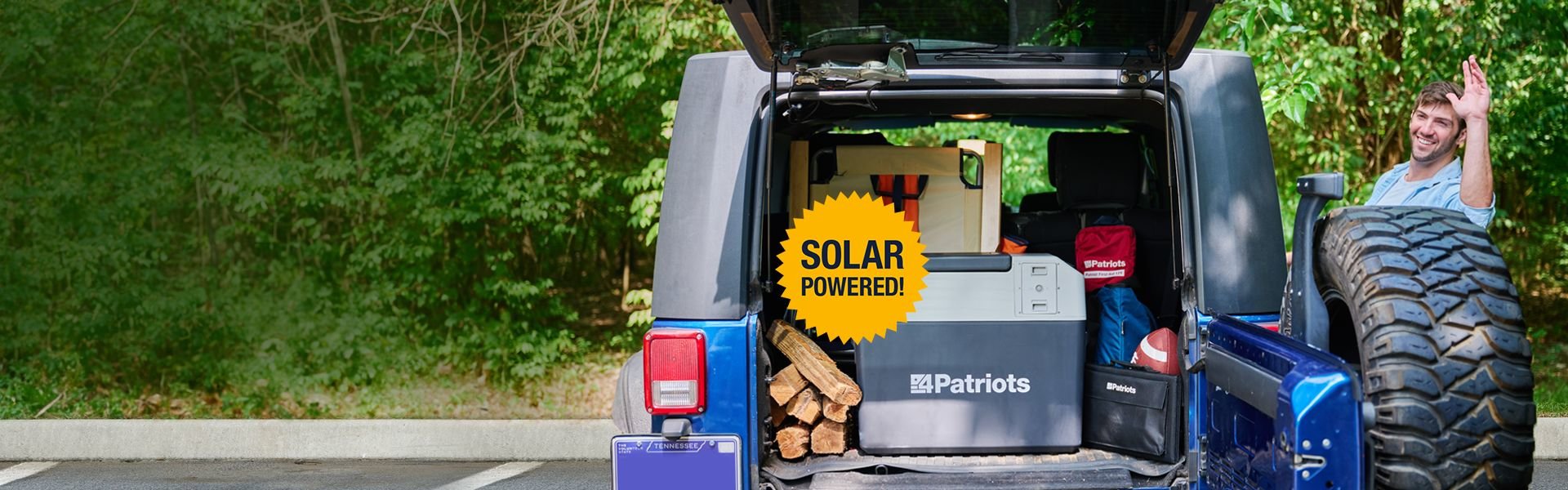 Man getting ready to start tailgating with his trunk open, Solar Go-Fridge and football ready to watch the game.