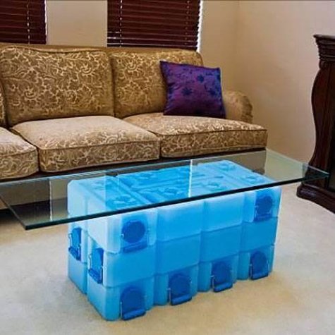 Stack of One Water brick storage containers holding a piece of glass like a coffee table.