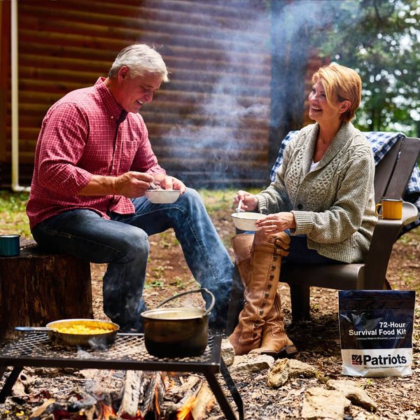 Man and woman enjoying 4Patriots Campfire Cooking Kit by the campfire making mac and cheese